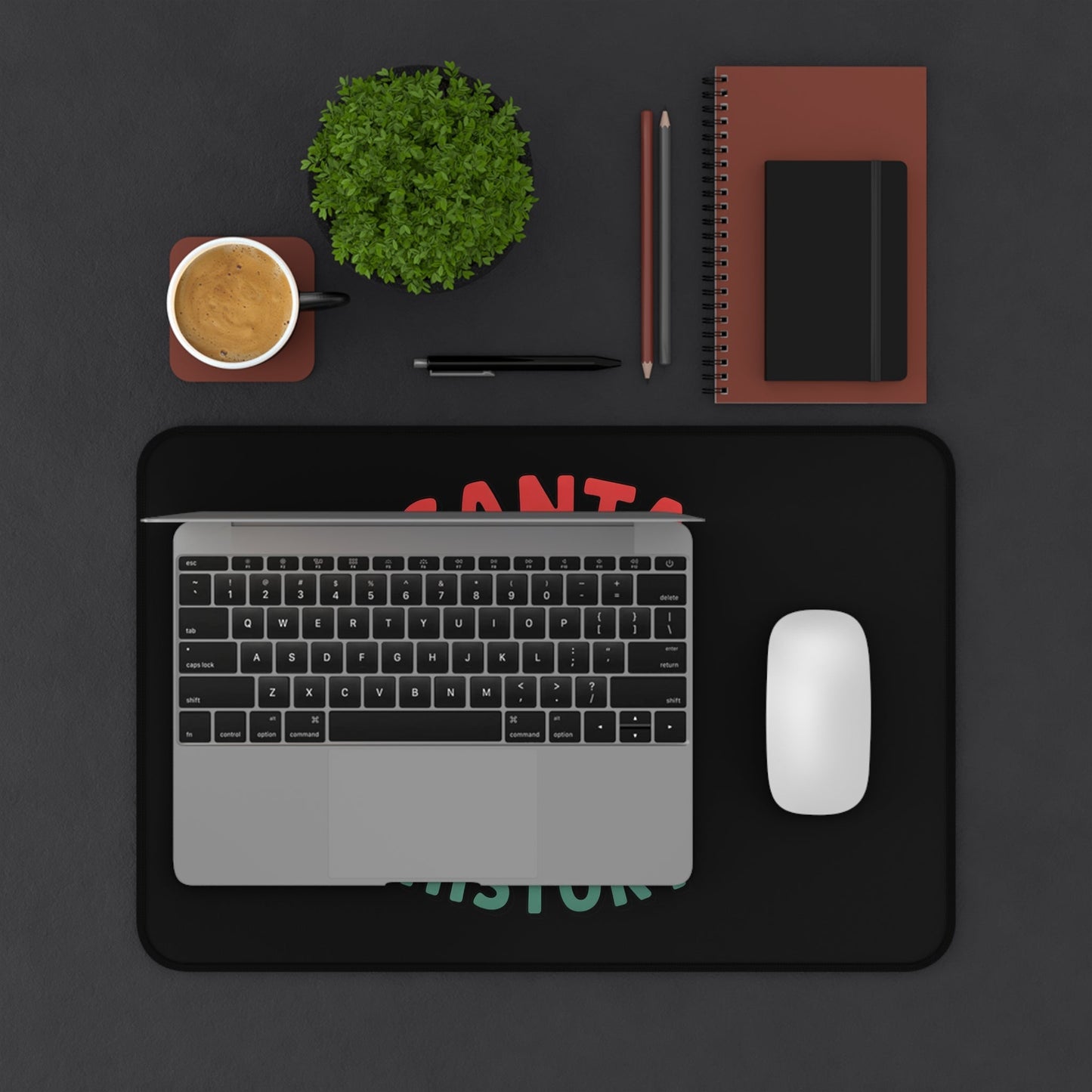 Funny Santa desk mat with humorous Christmas design under laptop and mouse on black desk setup