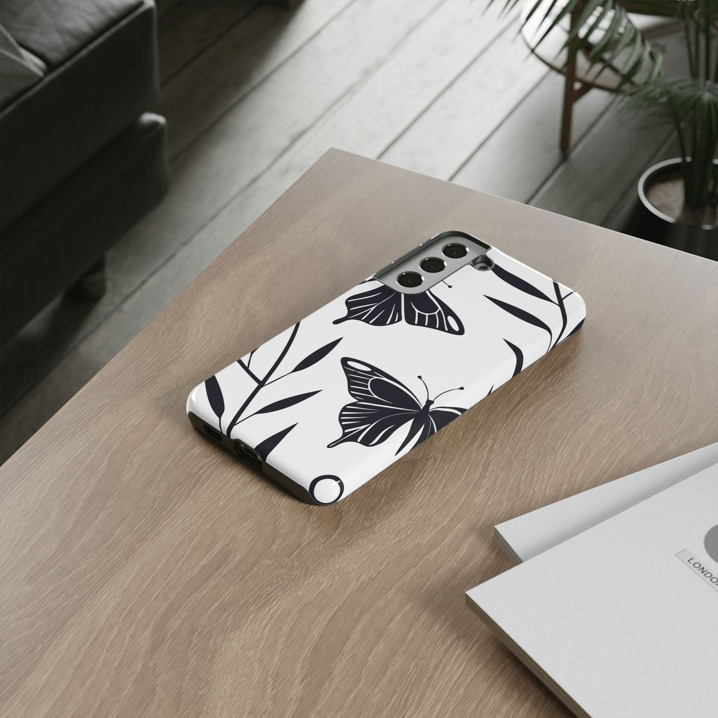 Minimalist black and white butterfly Samsung phone case on wooden table for sleek device protection