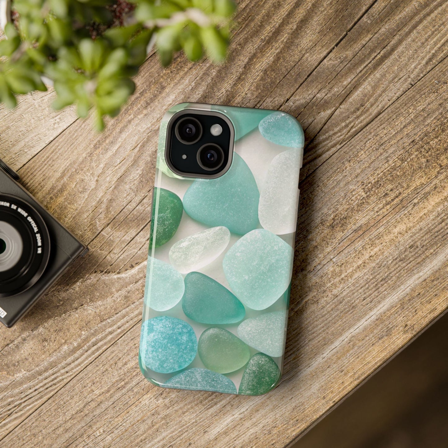 iPhone case with sea glass inspired design in calming blue and green tones on wooden surface