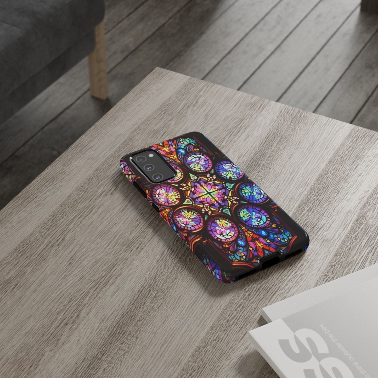 Samsung phone case with colorful hypnotic stained glass design on a wooden table