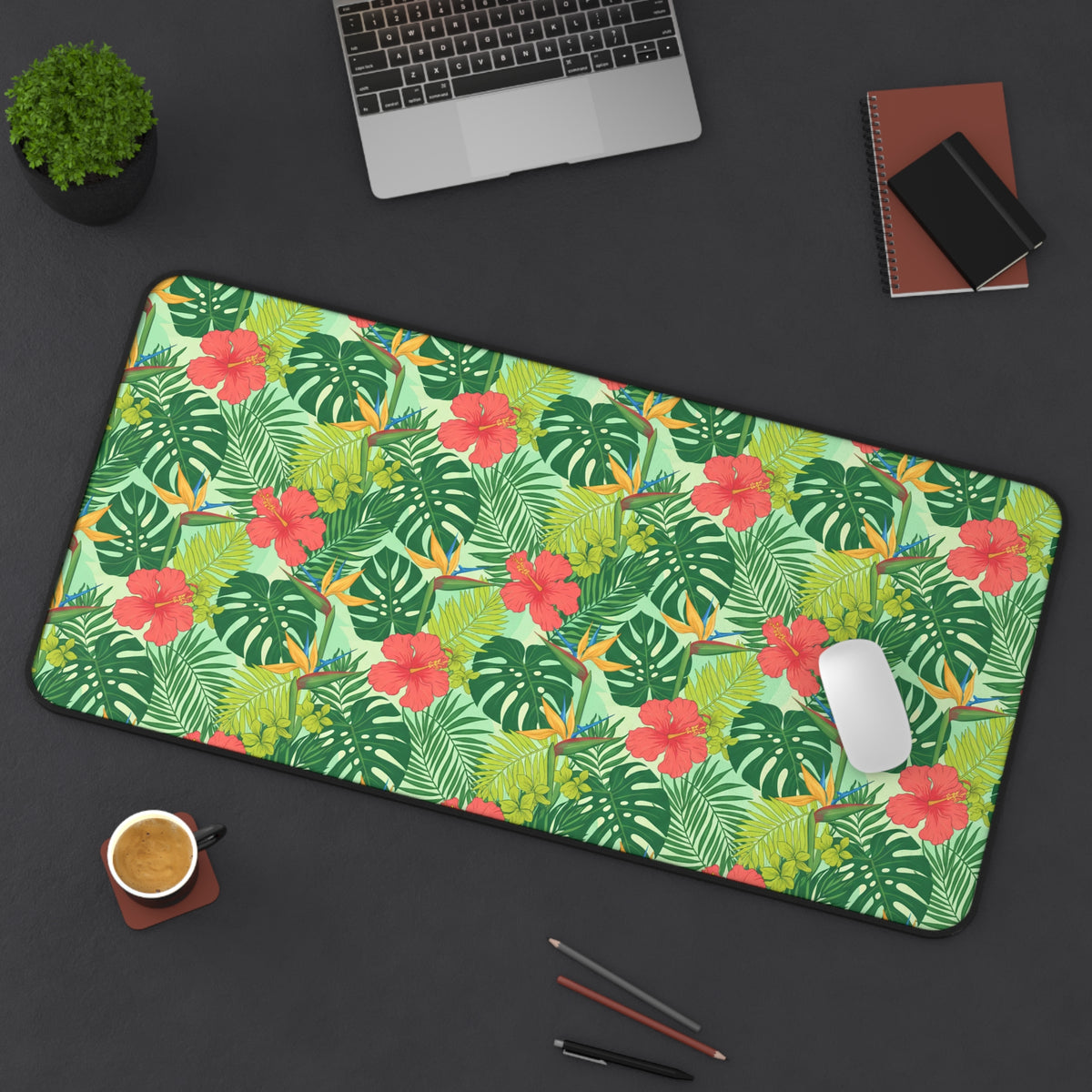 Tropical foliage and flowers on a large desk mat with a white mouse.