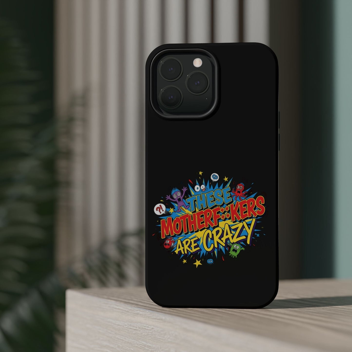 Black iPhone Case with colorful "These Motherf++kers Are Crazy" text and cartoon characters, impact-resistant design