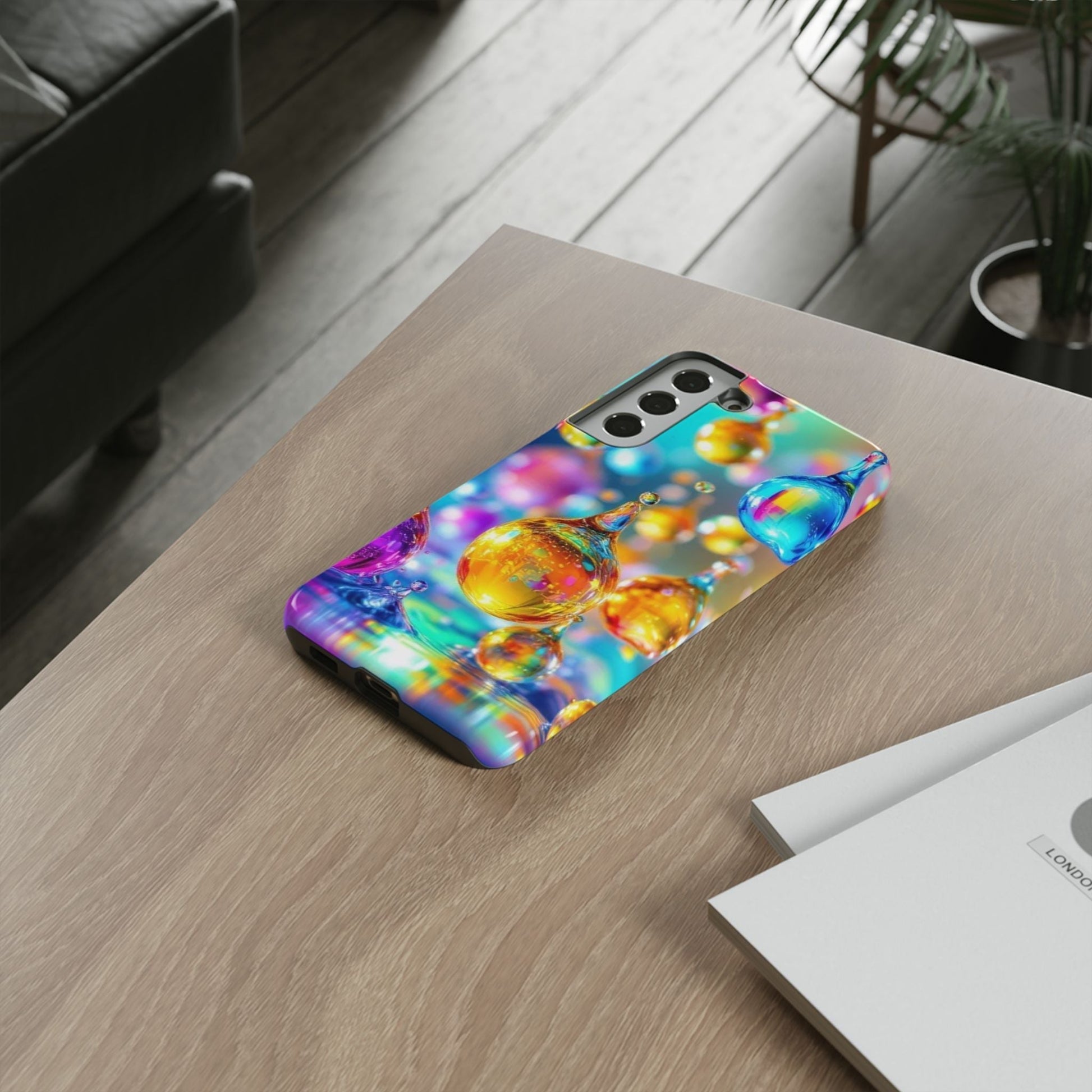 Samsung phone with vibrant Golden Raindrop Phone Case on wooden table, colorful 3D design with protective tough cover