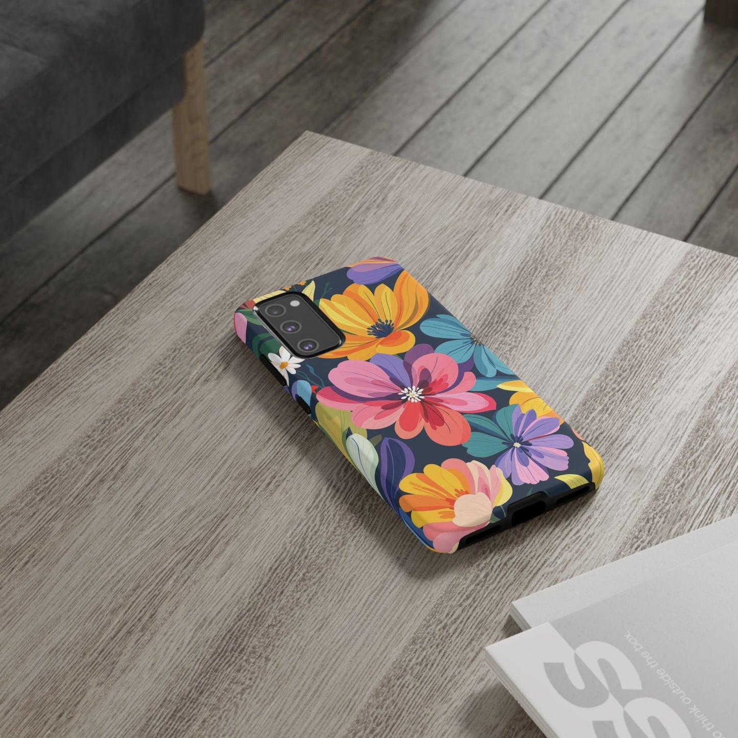 Colorful Floral Samsung Phone Case with vibrant flower design on wooden table, durable and shock-absorbing silicone liner, supports wireless charging