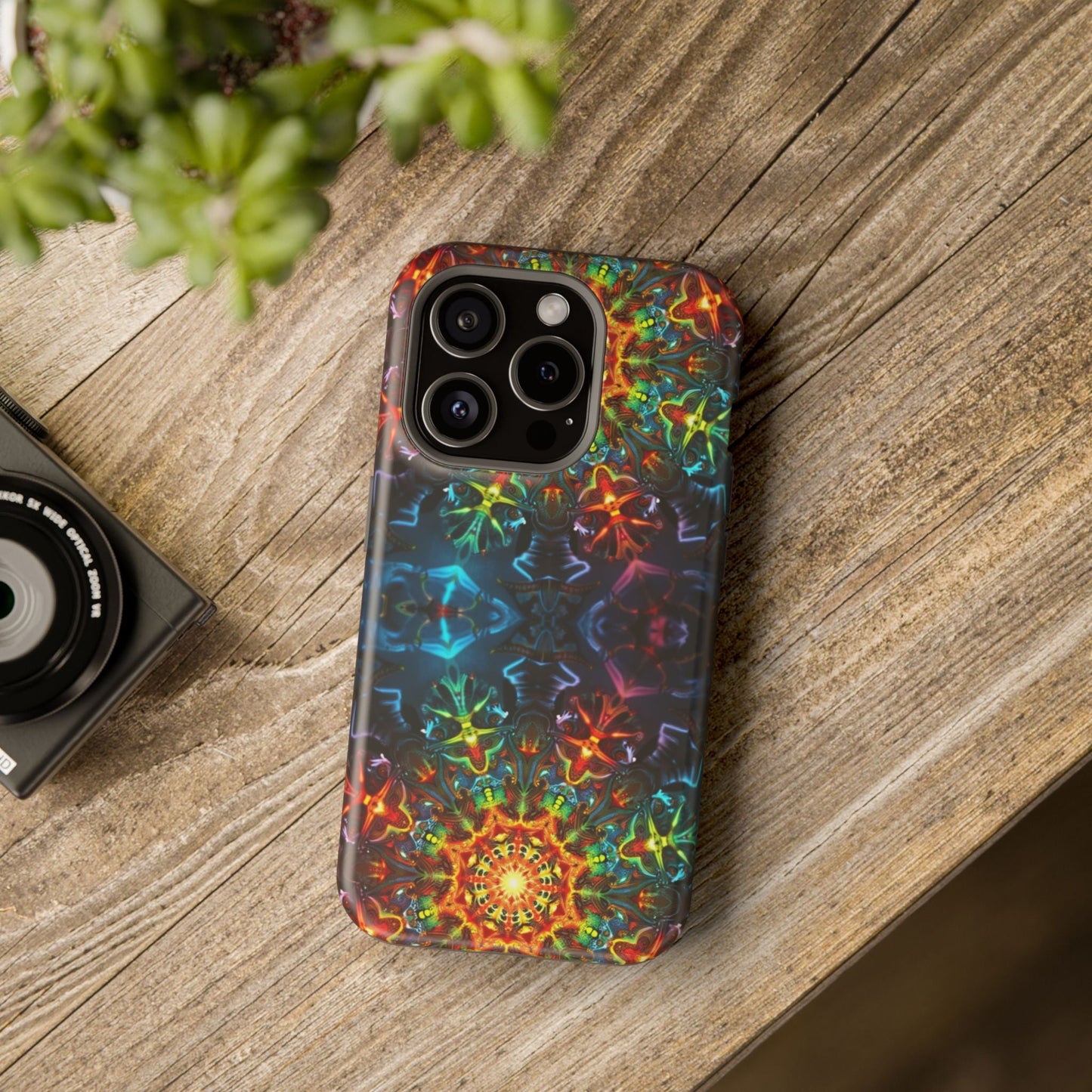 iPhone case with vibrant abstract kaleidoscope design in multiple colors on wooden surface