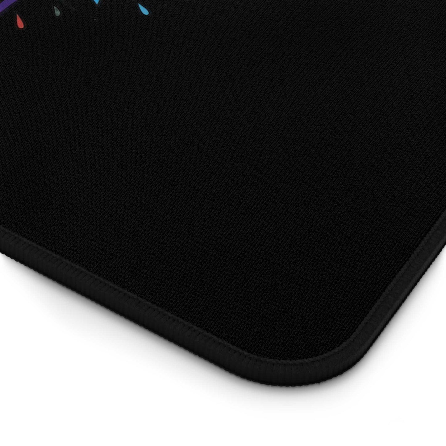 Close-up of black desk pad corner with hemmed edges and textured surface for office use