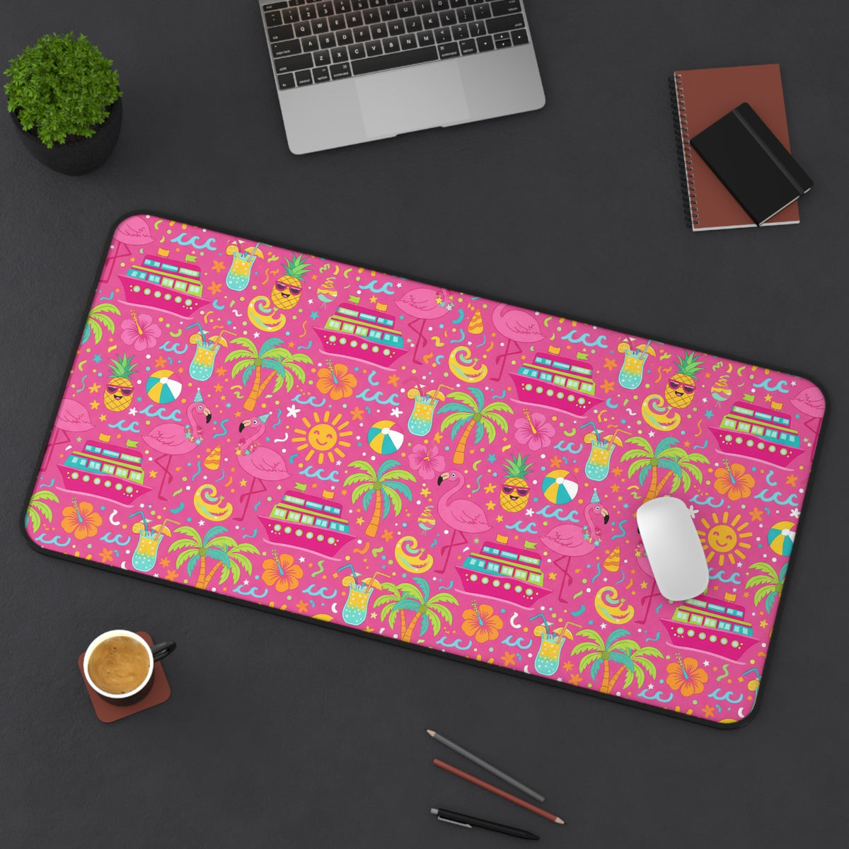 Pink desk mat with a repeating pattern of cruise ships, flamingos, pineapples, and tropical drinks.
