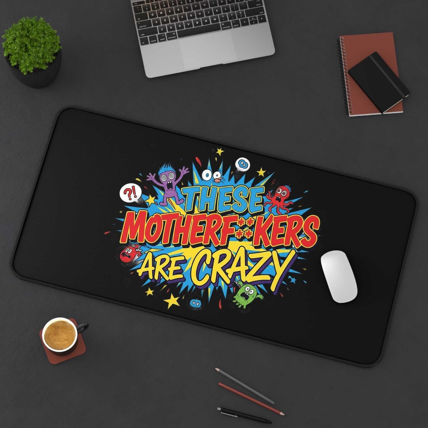 black desk pad with colorful "These Motherf++kers Are Crazy" text and cartoon monsters, non-slip office mat