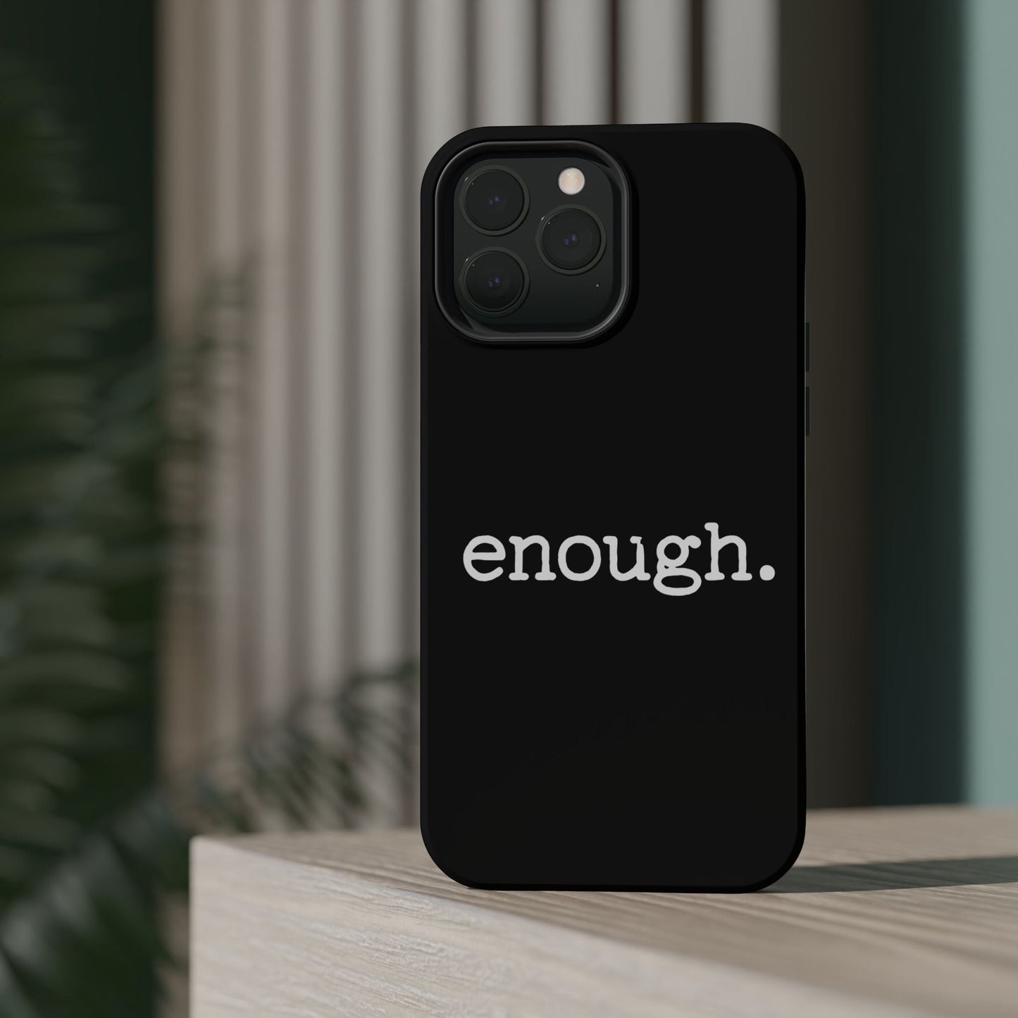 Black iPhone case with bold "enough." protest statement text, durable dual-layer protective design, MagSafe compatible