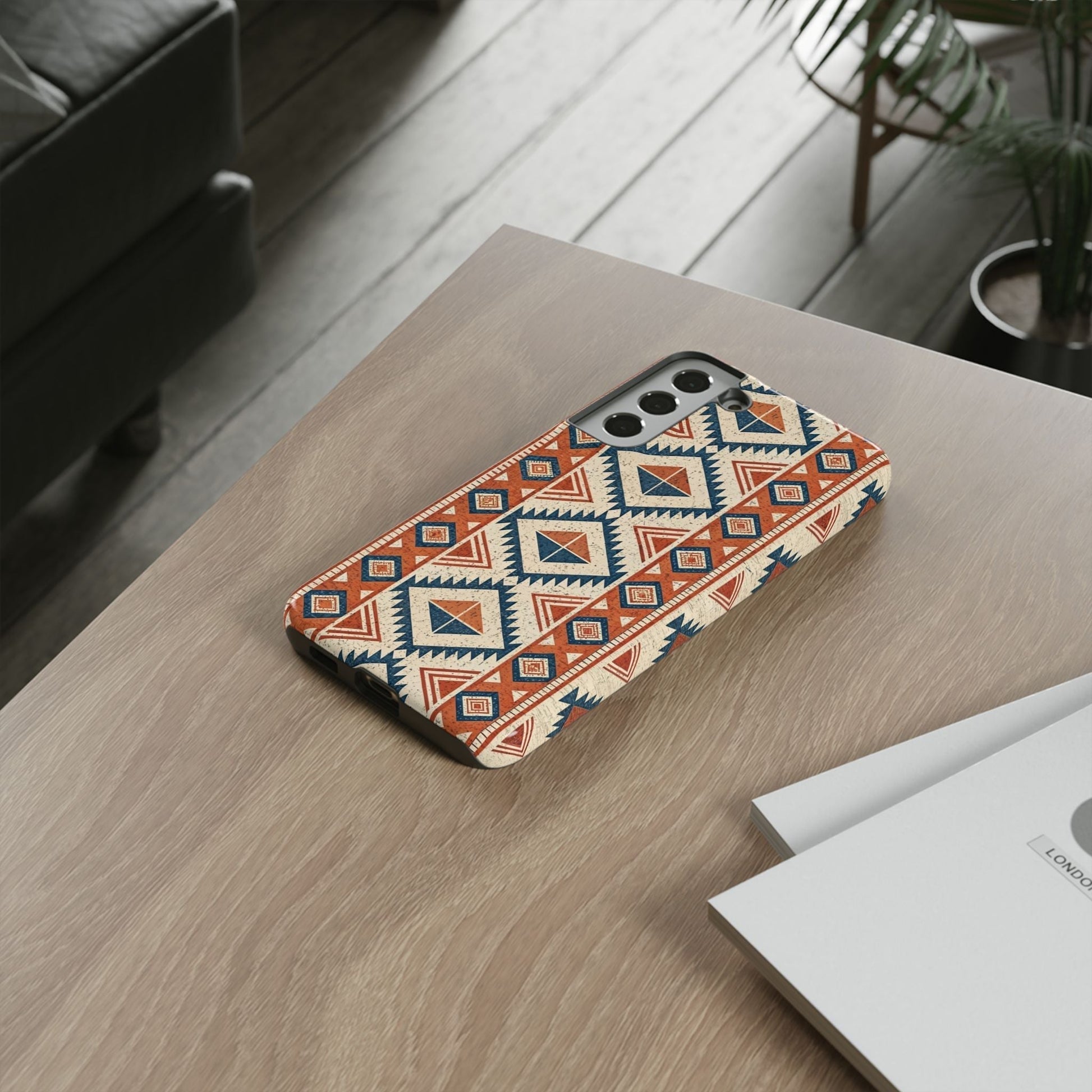 Tribal design Samsung phone case with orange and blue geometric pattern on wood table