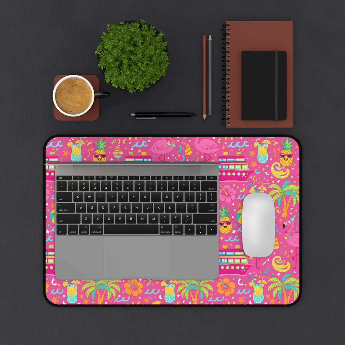 Desk mat with a bright pink tropical pattern featuring flamingos, pineapples, and cocktails.