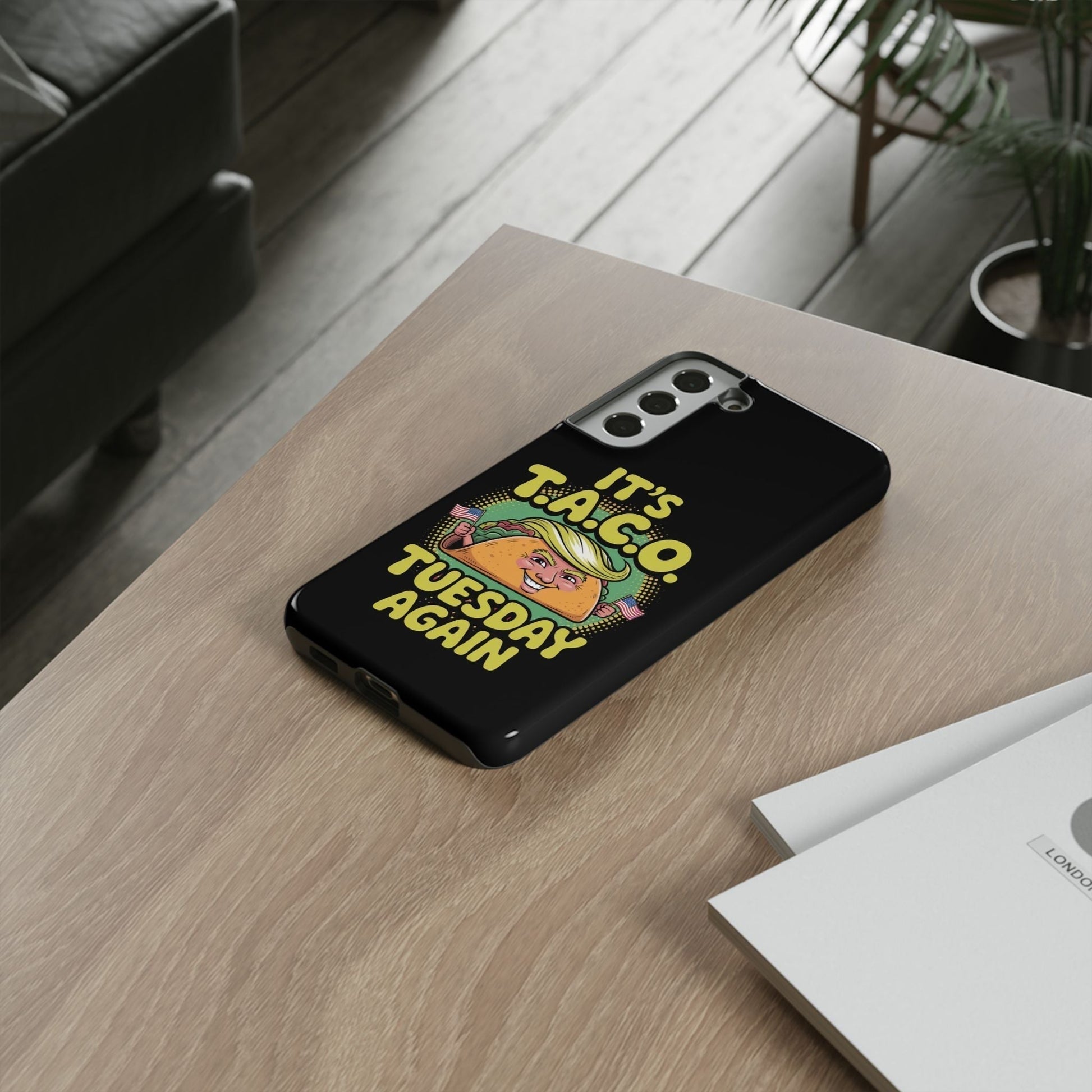 Samsung phone case with political satire Taco Tuesday design on black background placed on wooden table