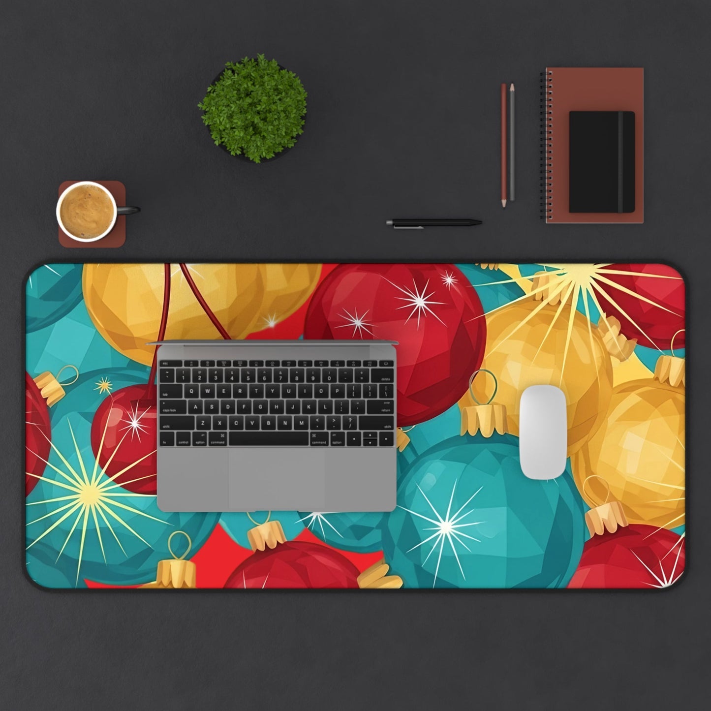 Colorful holiday-themed desk mat with sparkling Christmas tree bulb design on a workspace with laptop, mouse, coffee, and stationery items.