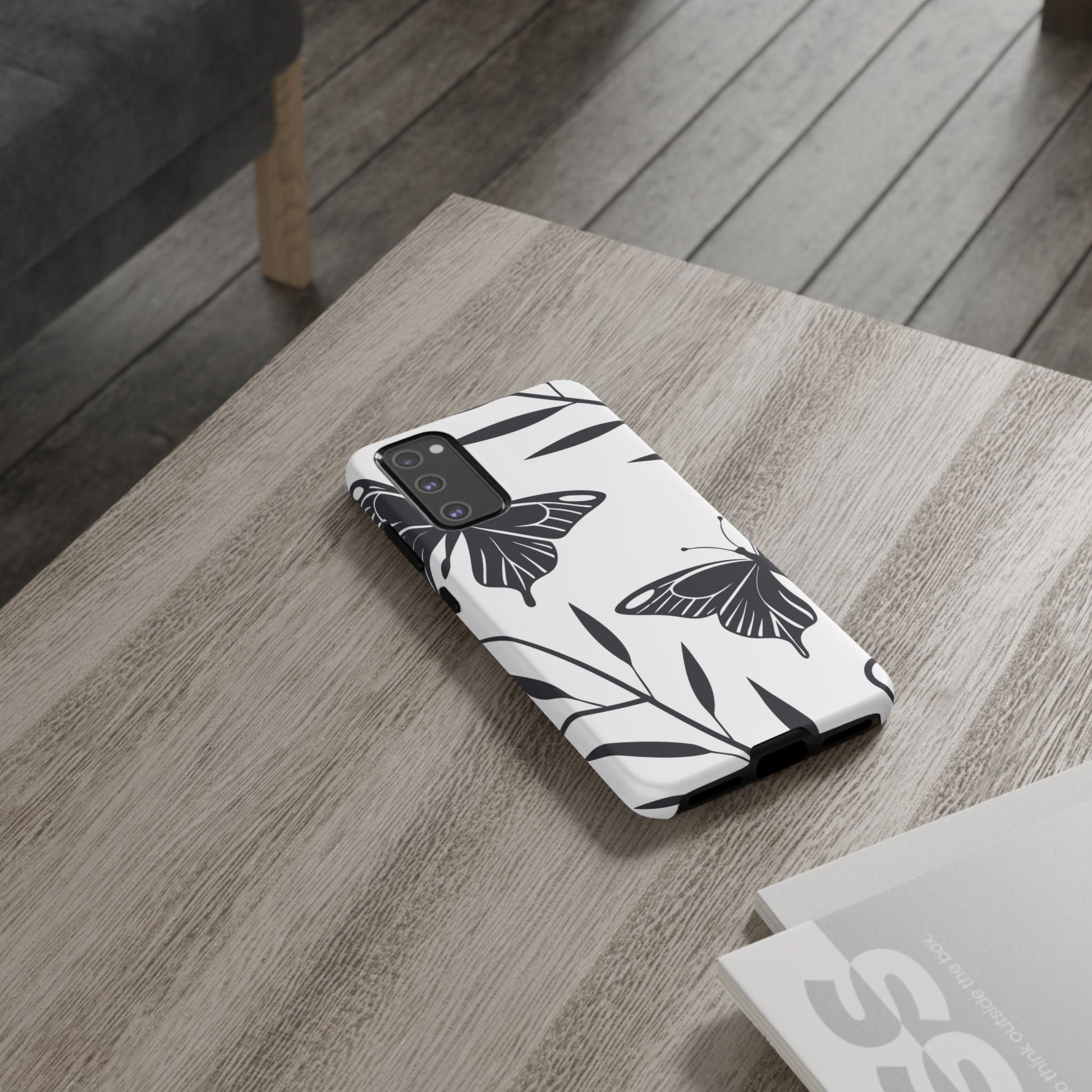 Minimalist black and white butterfly Samsung phone case on wooden table
