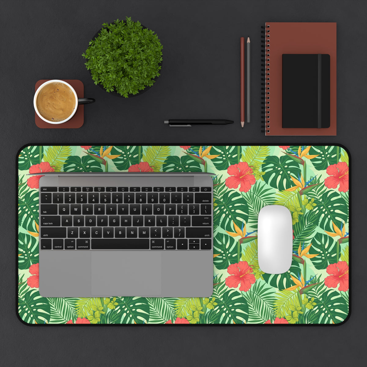 Tropical floral mousepad with laptop, mouse, coffee cup, and plant.