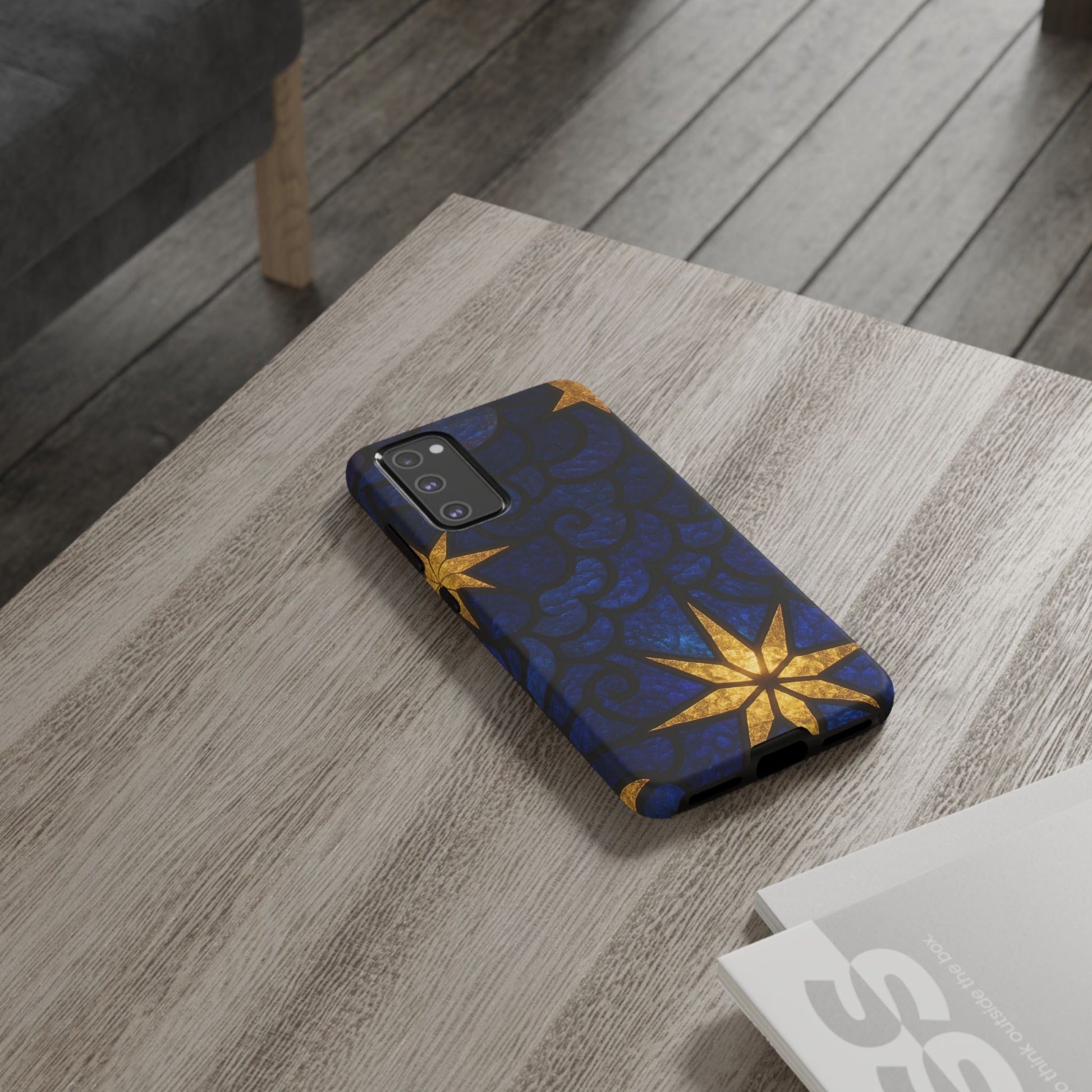 Samsung phone with Golden Star Samsung tough case featuring a blue background and gold star design on a wooden table