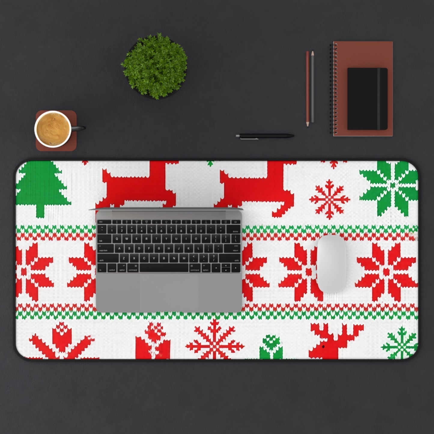 Festive ugly sweater inspired desk mat with red and green holiday patterns, non-slip and hemmed edges, featuring laptop and mouse on black desk.